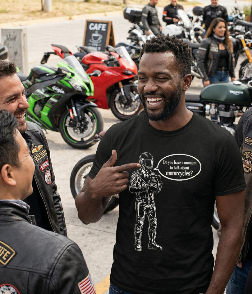 Man wearing a Motovangelist t-shirt and laughing with his friends with motorcycles parked in the background