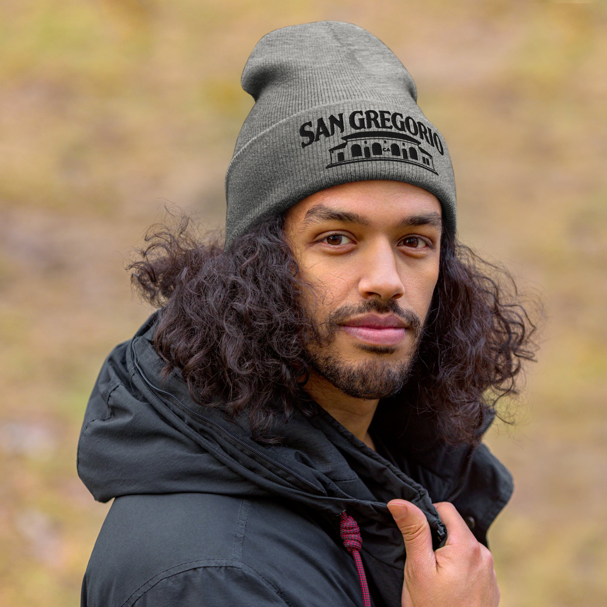 man wearing grey beanie with San Gregorio General Store design embroidered on cuff