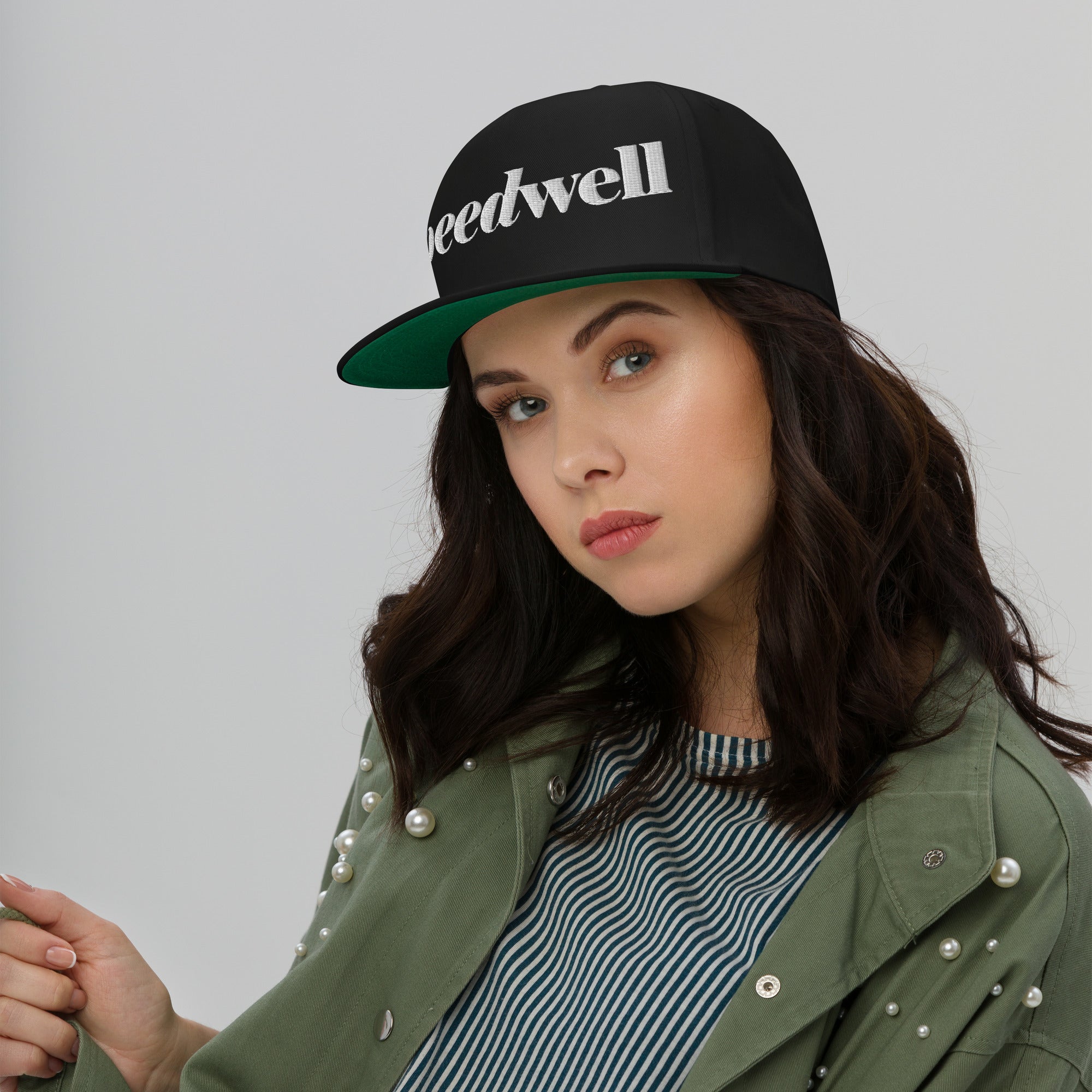 woman wearing black baseball cap with SPEEDWELL logo embroidered on front