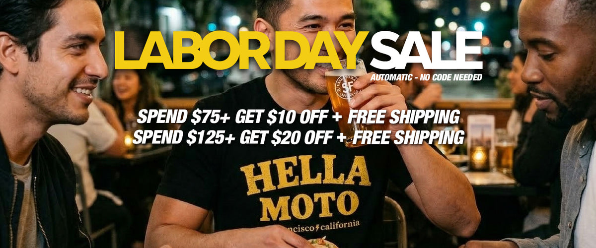 Promotional Labor Day Sale banner featuring three men in a bar setting, with large yellow and white text reading 'LABOR DAY SALE' and offer details: 'SPEND $75+ GET $10 OFF + FREE SHIPPING' and 'SPEND $125+ GET $20 OFF + FREE SHIPPING'. The central man wears a black graphic T-shirt with yellow 'HELLA MOTO' lettering.