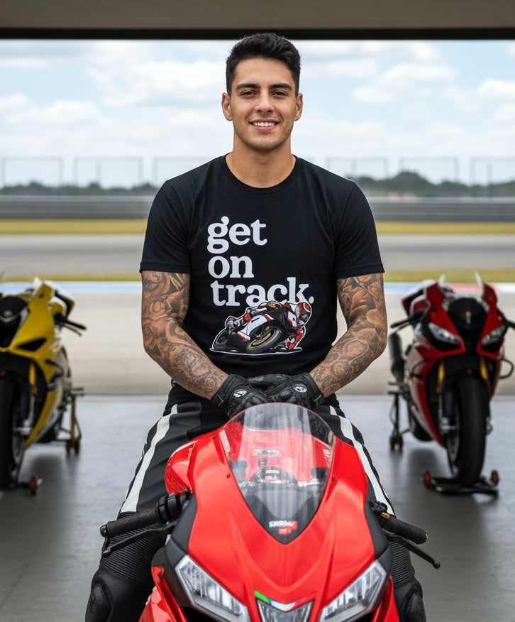 Man wearing a "get on track" t-shirt sitting on a sportbike motorcycle at the racetrack