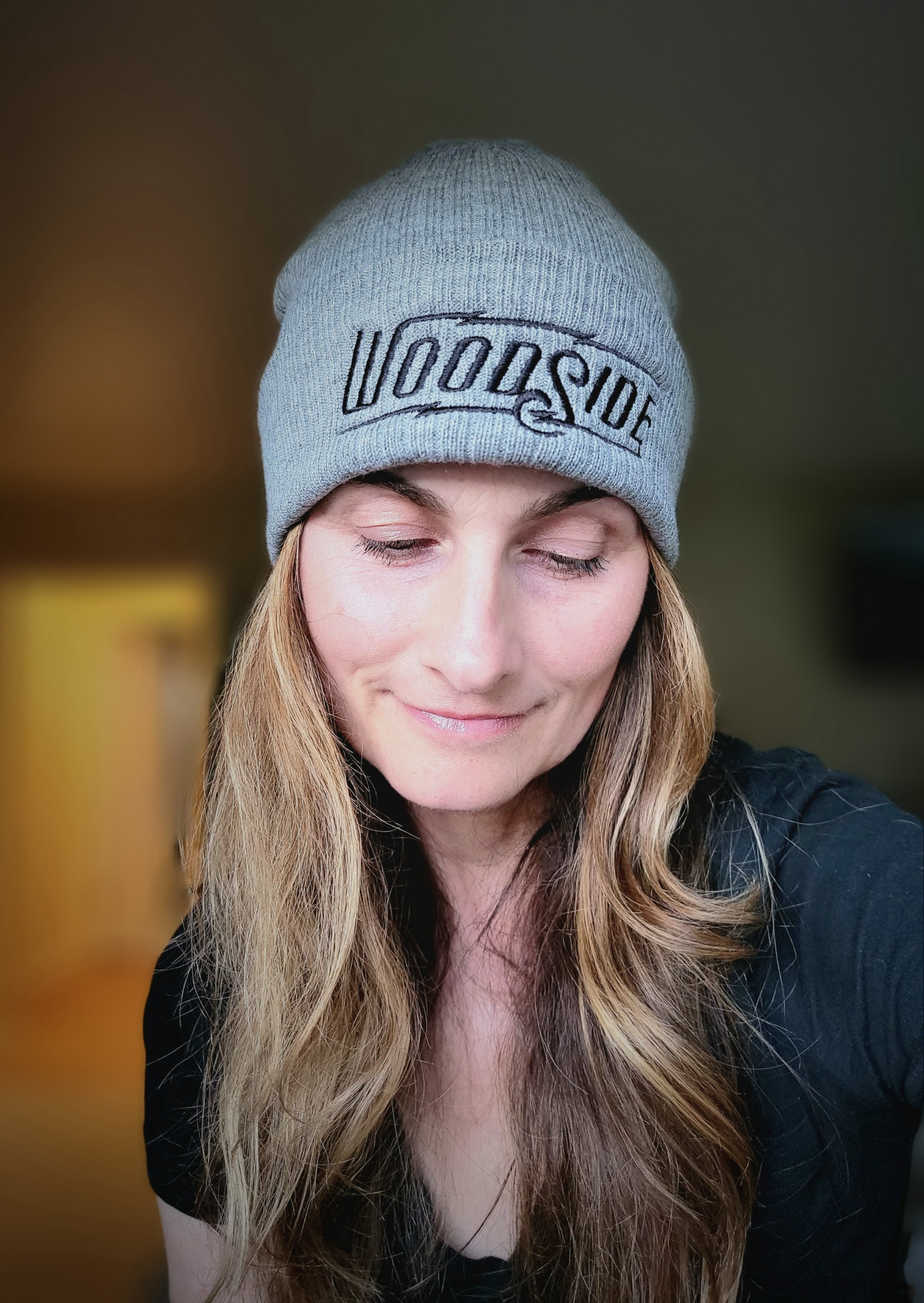 Beautiful woman wearing a grey embroidered Woodside Brand beanie