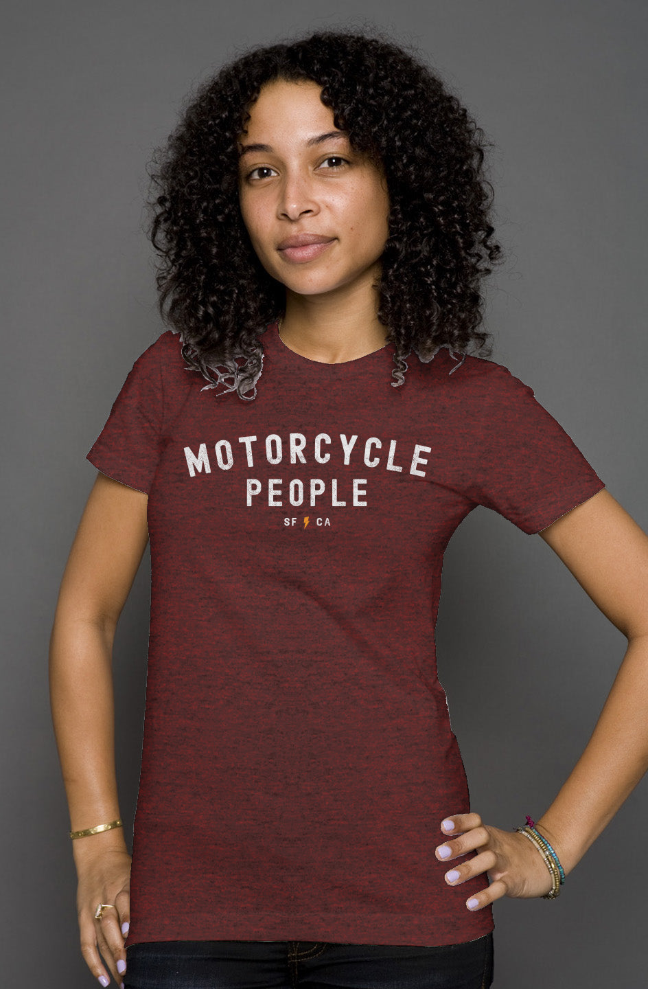 Attractive woman wearing heather short sleeve t-shirt with "motorcycle people" SF CA design on chest