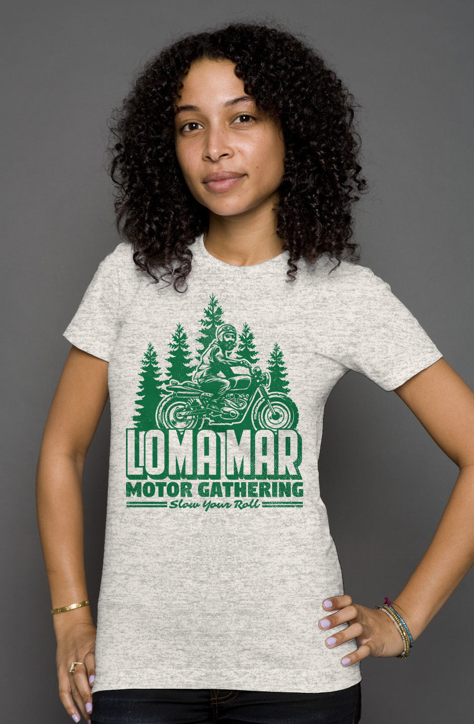 Woman wearing grey short sleeve t-shirt with original Loma mar motor gathering design on chest in green