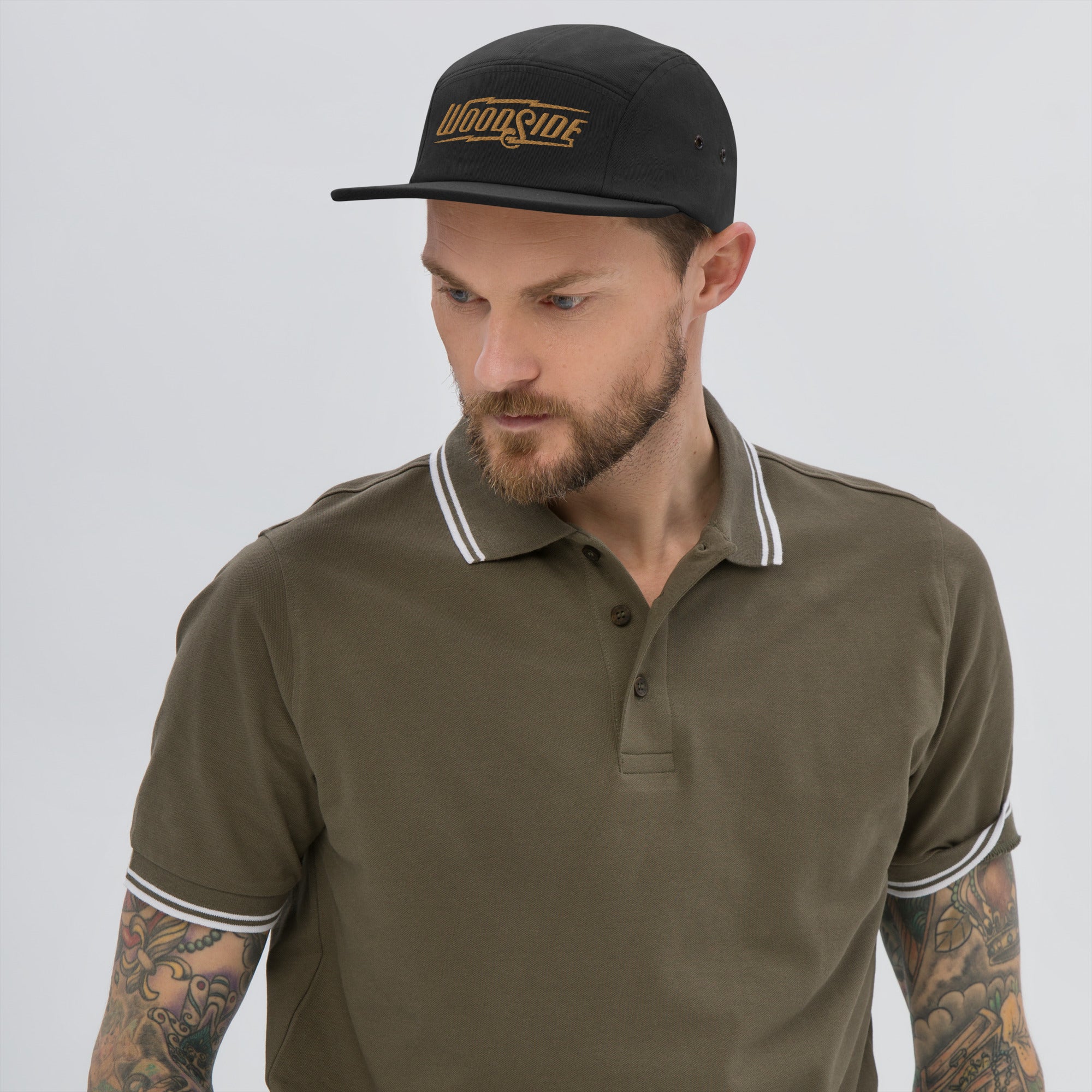 Man wearing black Woodside Brand embroidered camper hat with gold embroidery