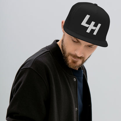 Man wearing trucker hat with La Honda california LH shift pattern design embroidered on front