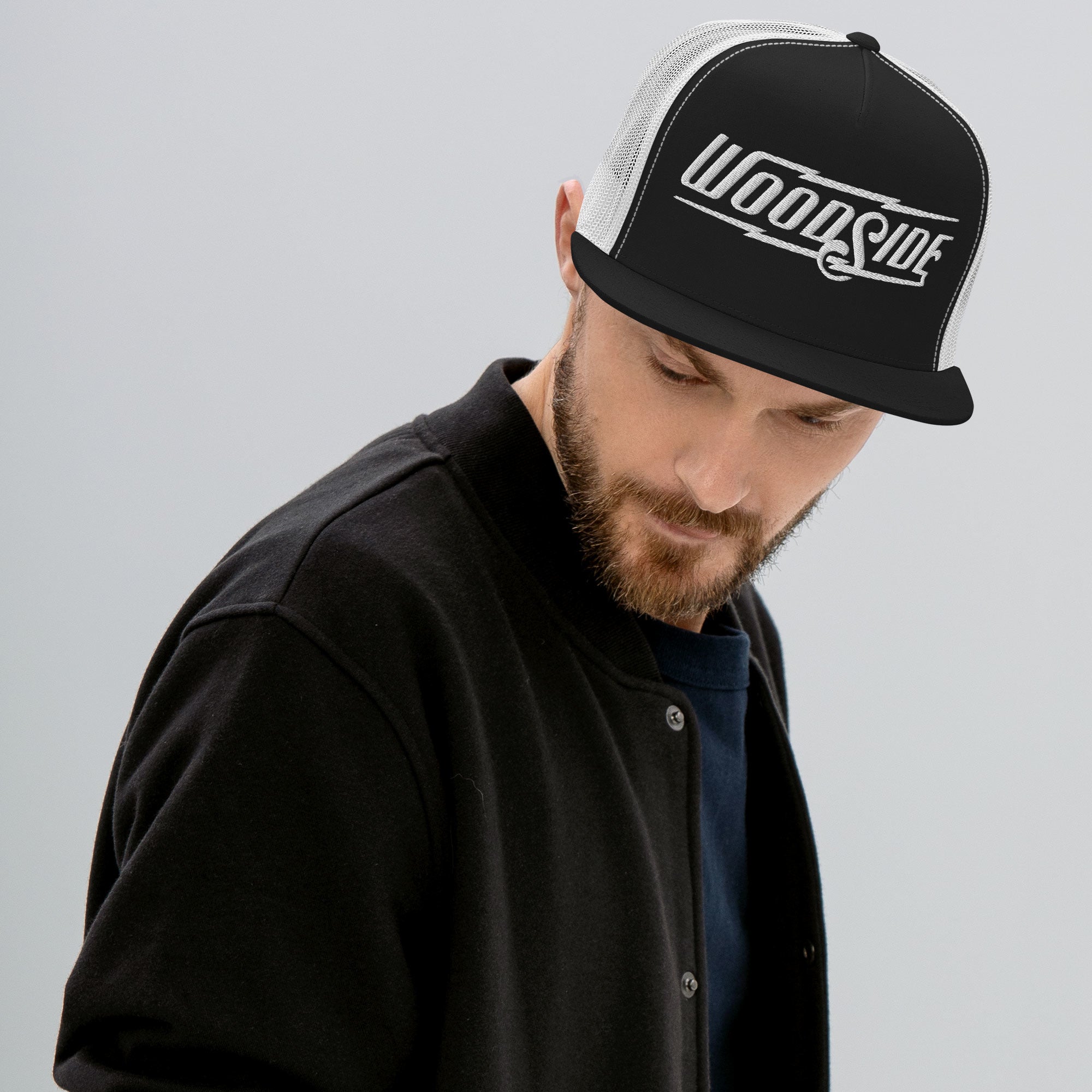 Man wearing Woodside Brand embroidered snapback trucker hat with white embroidery