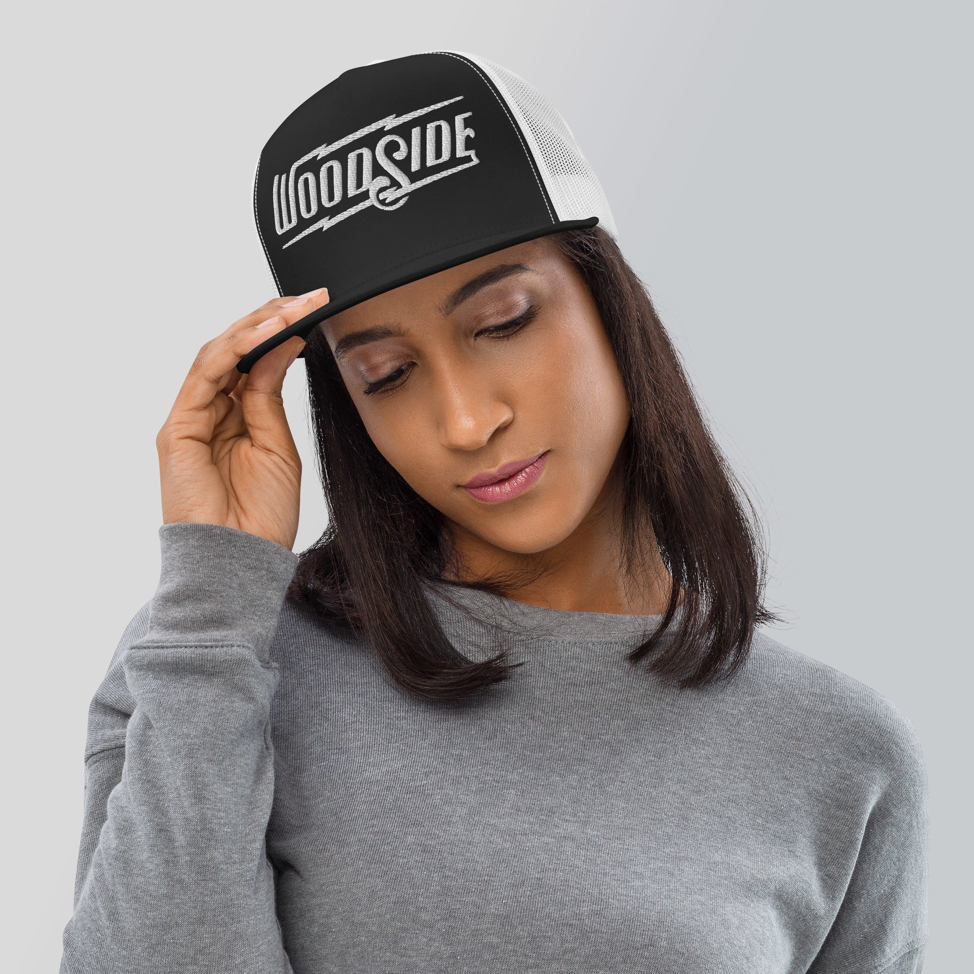 Woman wearing Woodside Brand embroidered snapback trucker hat with white embroidery