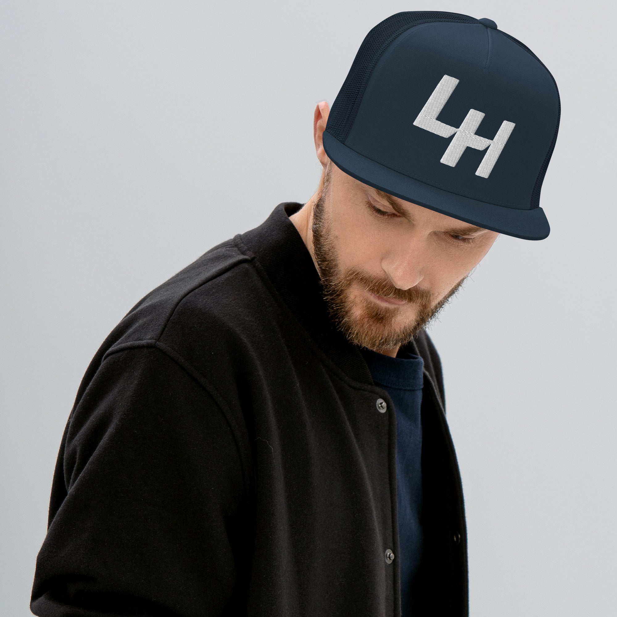 Man wearing trucker hat with La Honda california LH shift pattern design embroidered on front