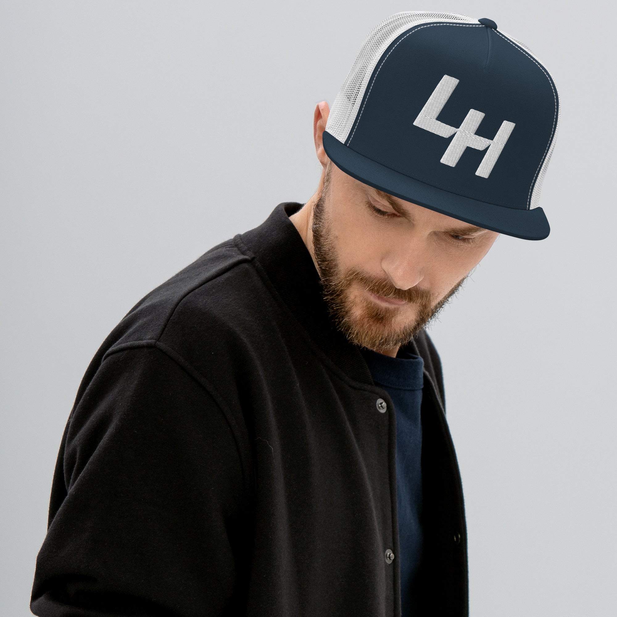 Man wearing trucker hat with La Honda california LH shift pattern design embroidered on front