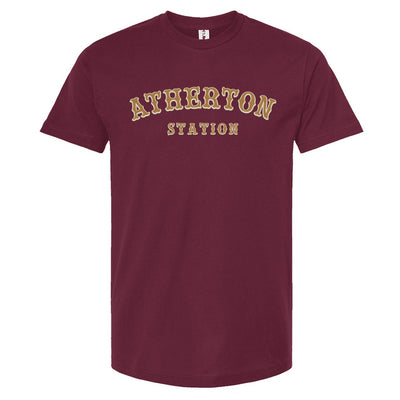 Burgundy t-shirt with 'Atherton Station' in gold and cream on the chest