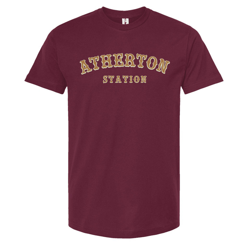 Burgundy t-shirt with 'Atherton Station' in gold and cream on the chest