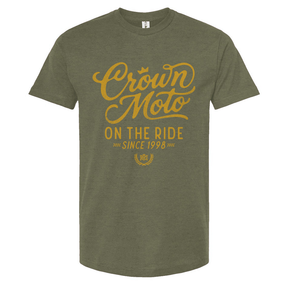 An olive green short-sleeve t-shirt with a gold graphic print on the front reading 'Crown Moto ON THE RIDE SINCE 1998'.