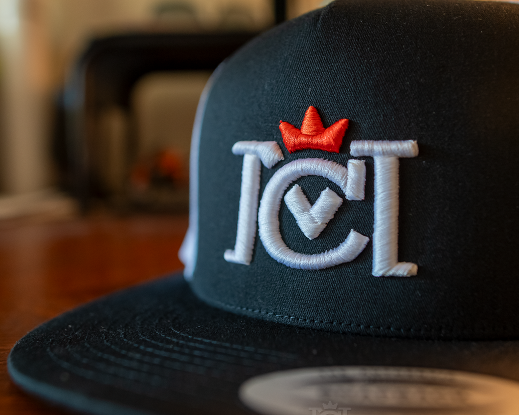 Black cap with Crown Moto 3D embroidered logo on a blurred background