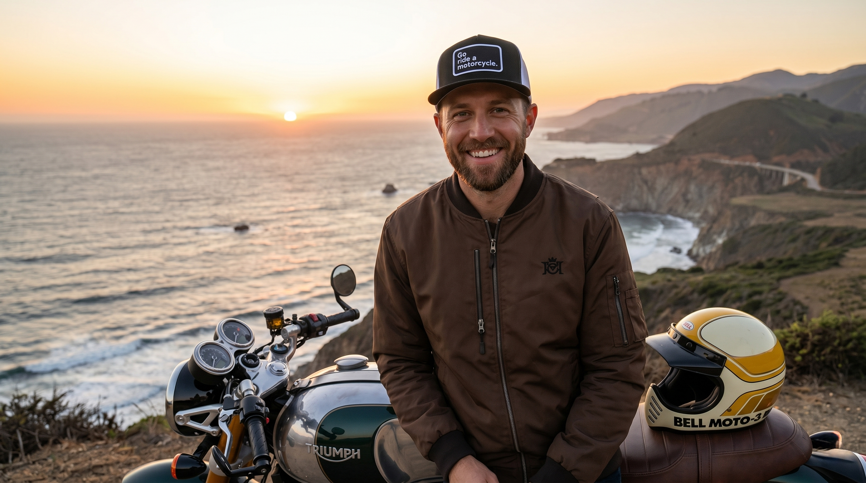 Man sitting on a motorcycle with a scenic ocean view at sunset