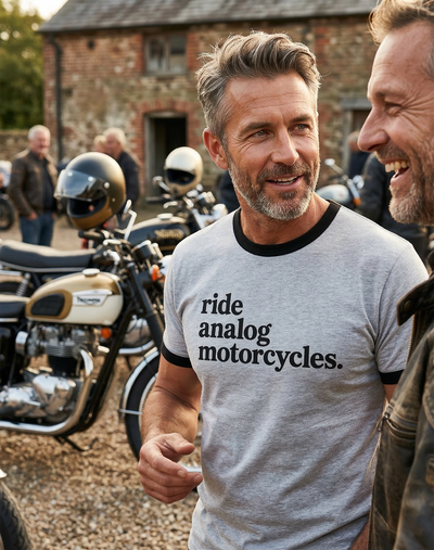 Man wearing a "Ride Analog Motorcycles" t-shirt with classic British motorcycles in the background