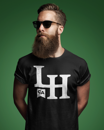 Bearded man wearing black t-shirt with La Honda LH monogram design on chest