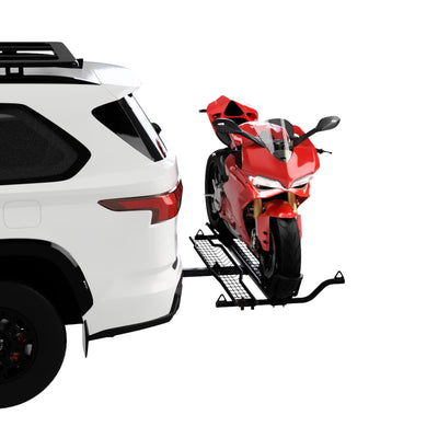 Red motorcycle on a trailer attached to a white SUV against a white background