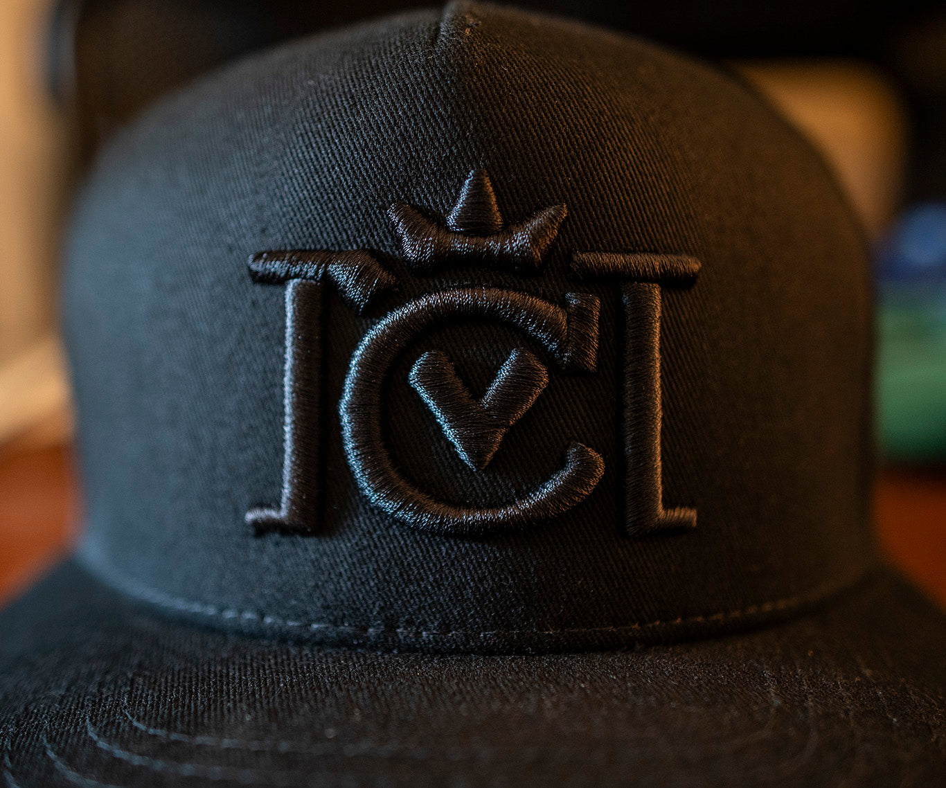 Trademarked Crown Moto logo embroidered in black 3d puff style on front of black snapback hat