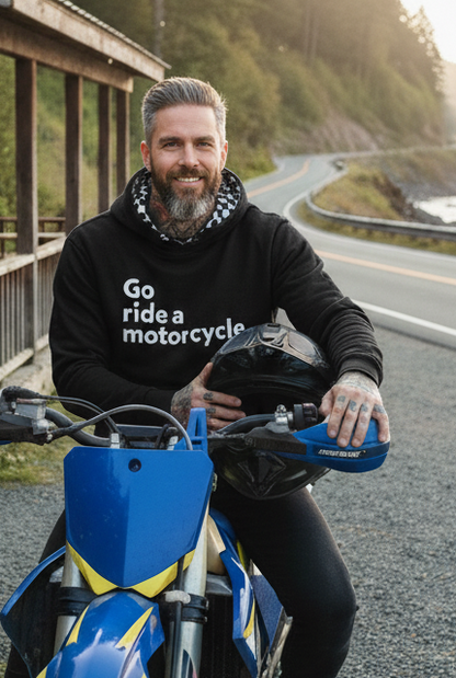 Man sitting on a supermoto motorcycle wearing a "Go ride a motorcycle" hoodie with checkered flag lined hood