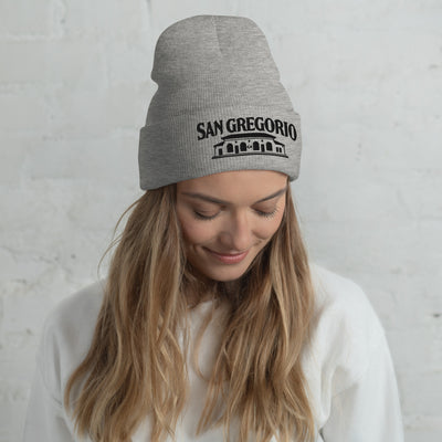 Woman wearing grey beanie with San Gregorio General Store design embroidered on cuff