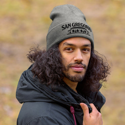 man wearing grey beanie with San Gregorio General Store design embroidered on cuff