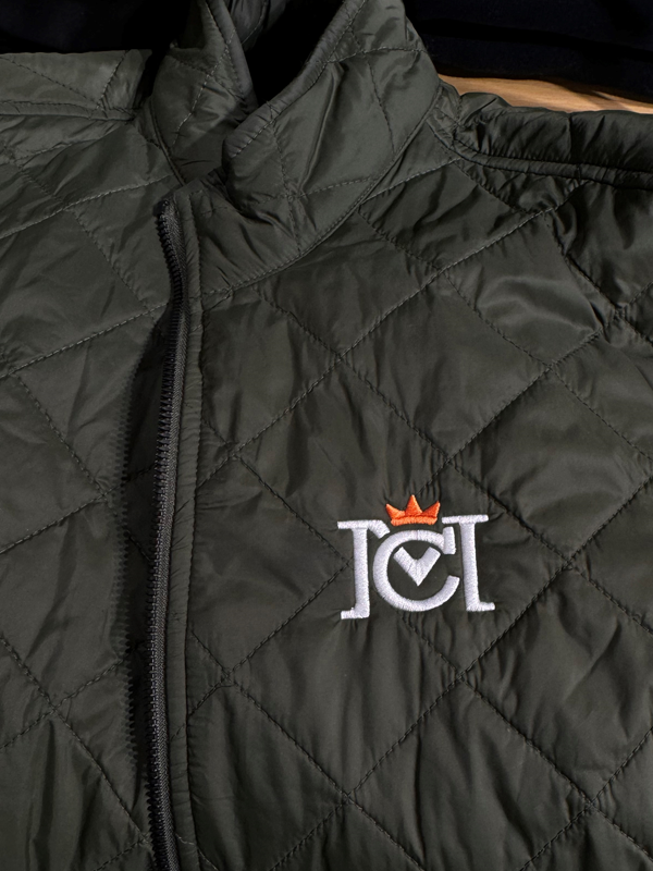 close-up image of crown moto logo embroidered on black quilted puffer jacket