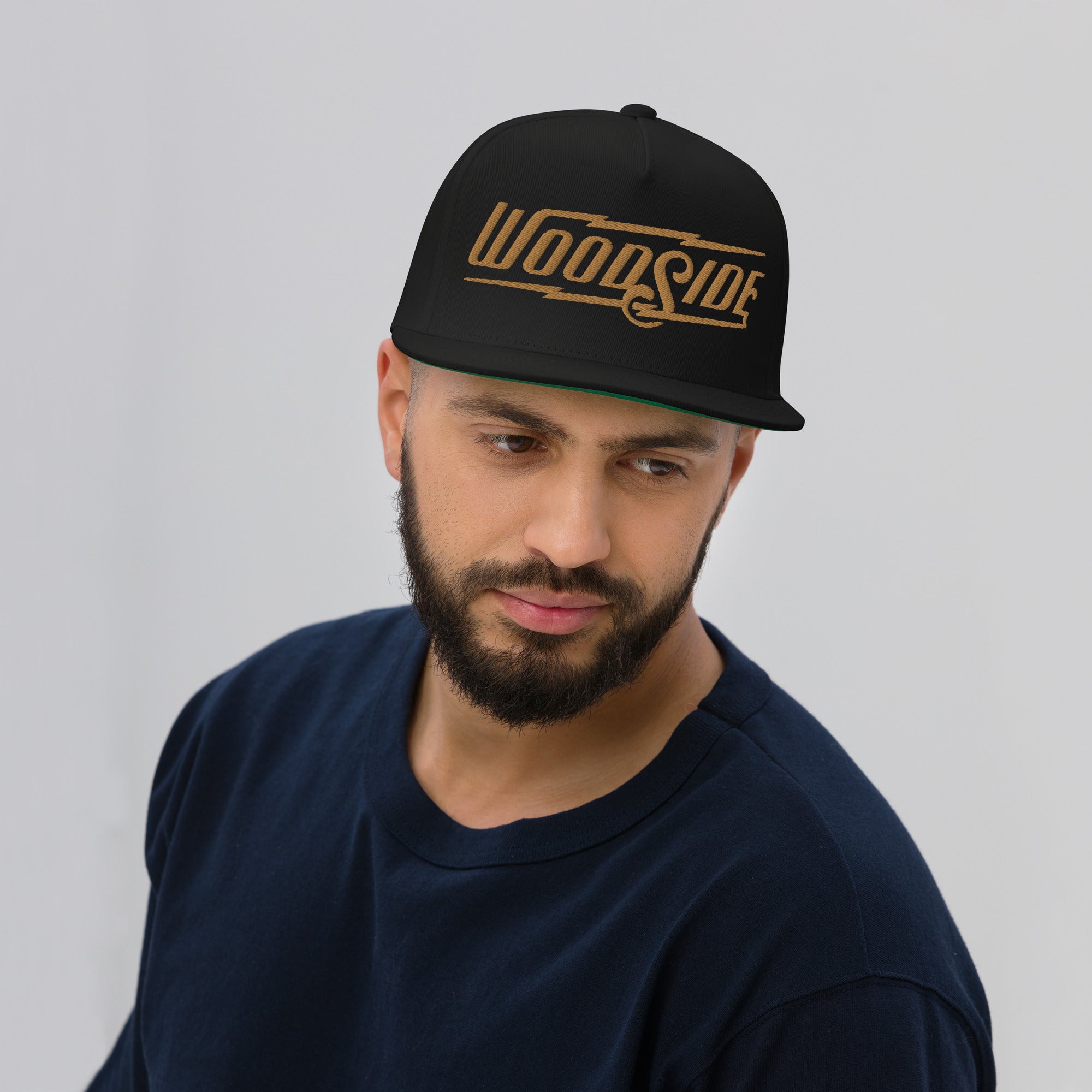 Bearded man wearing Black Woodside Brand embroidered snapback hat with gold embroidery