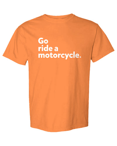 An orange short-sleeve crewneck t-shirt with the phrase 'Go ride a motorcycle.' printed in white sans-serif text on the chest