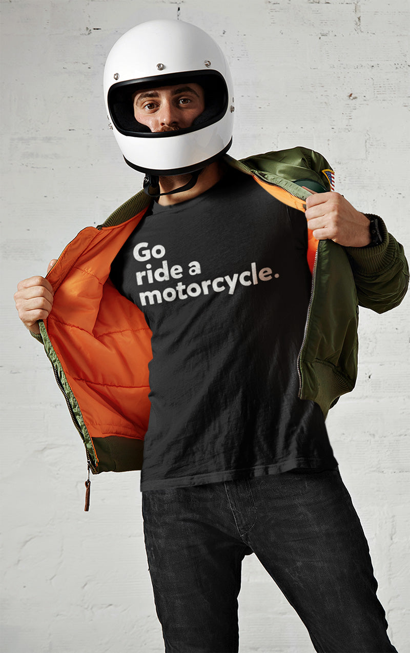 Man wearing motorcycle helmet and opening jacket to show black t-shirt with "Go ride a motorcycle" design printed on chest