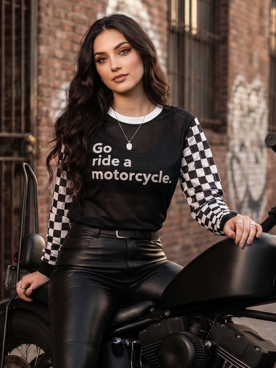 Woman wearing a crown moto 'Go ride a motorcycle' mx jersey sitting on a motorcycle