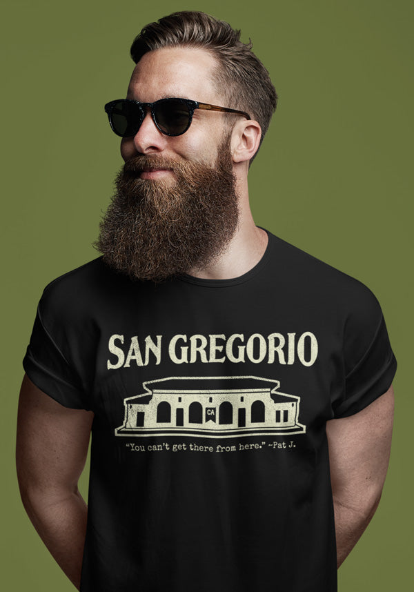 Bearded man wearing a black t-shirt with San Gregorio General Store design printed on chest in cream