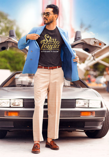 man wearing a "Sky Londa Motor Club" t-shirt and sport coat standing in front of a Delorean car