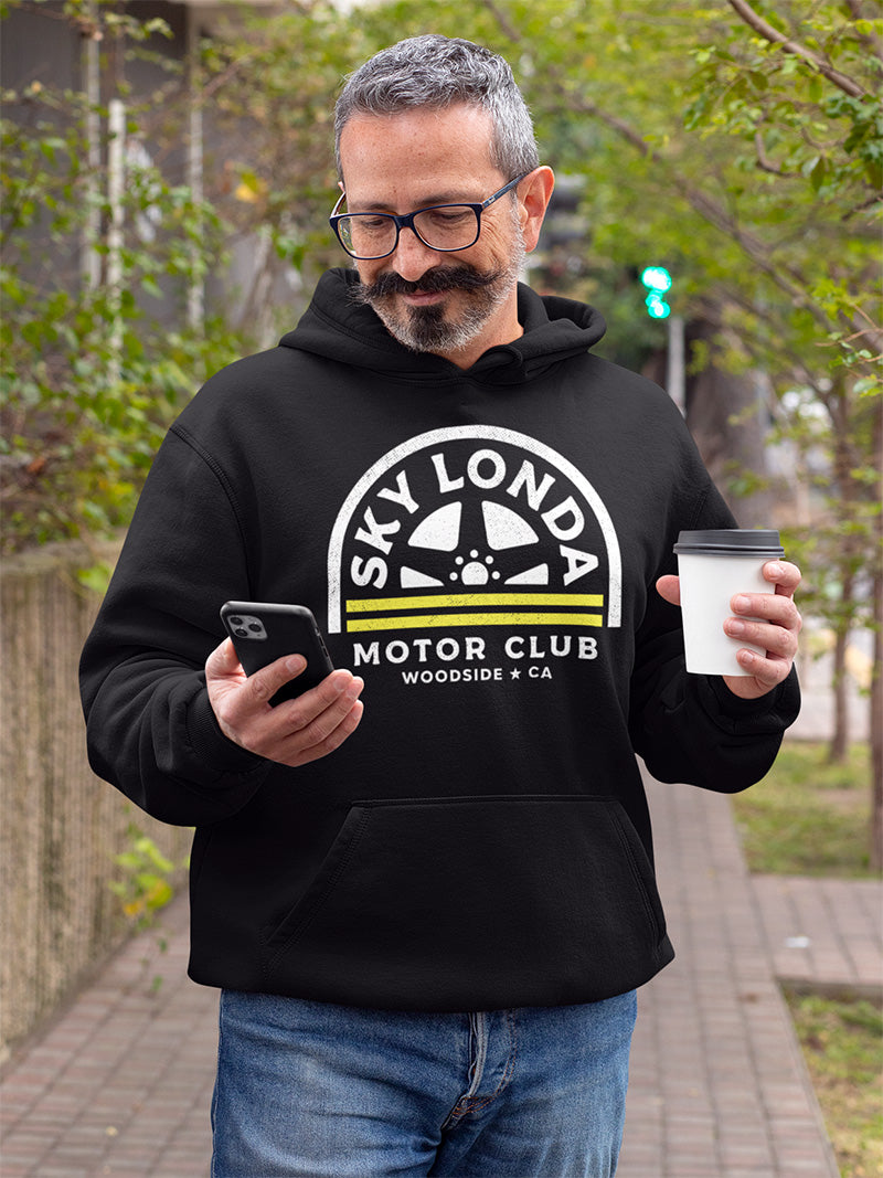 Man wearing "Sky Londa Motor Club" wheel logo on chest of black hooded sweatshirt