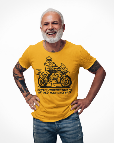 Older man wearing a t-shirt with rider on a GS motorcycle sitting proudly with text below saying "never underestimate an old man on a gs"