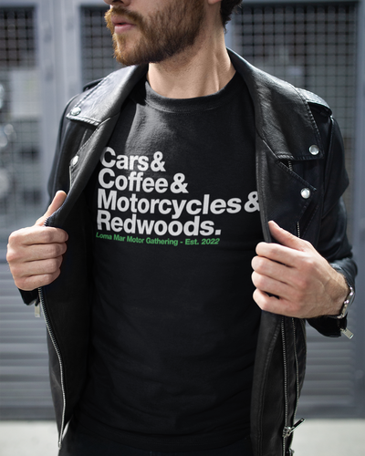 Man in leather jacket wearing a Loma Mar Motor Gathering Cars and Coffee 2025 T-Shirt