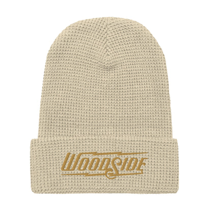 Product mockup of Woodside brand waffle knit beanie with Woodside Brand logo embroidered in gold on front cuff