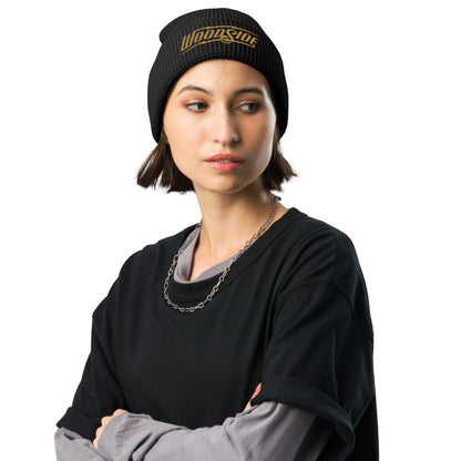 Female model wearing a Woodside brand waffle knit beanie with Woodside Brand logo embroidered in gold on front cuff