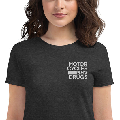 woman wearing short sleeve t-shirt with "Motorcycles are drugs" logo embroidered in white on left chest