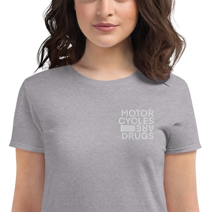 woman wearing short sleeve t-shirt with "Motorcycles are drugs" logo embroidered in white on left chest