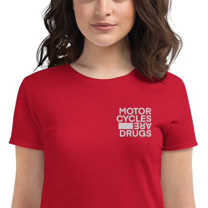 woman wearing short sleeve t-shirt with "Motorcycles are drugs" logo embroidered in white on left chest