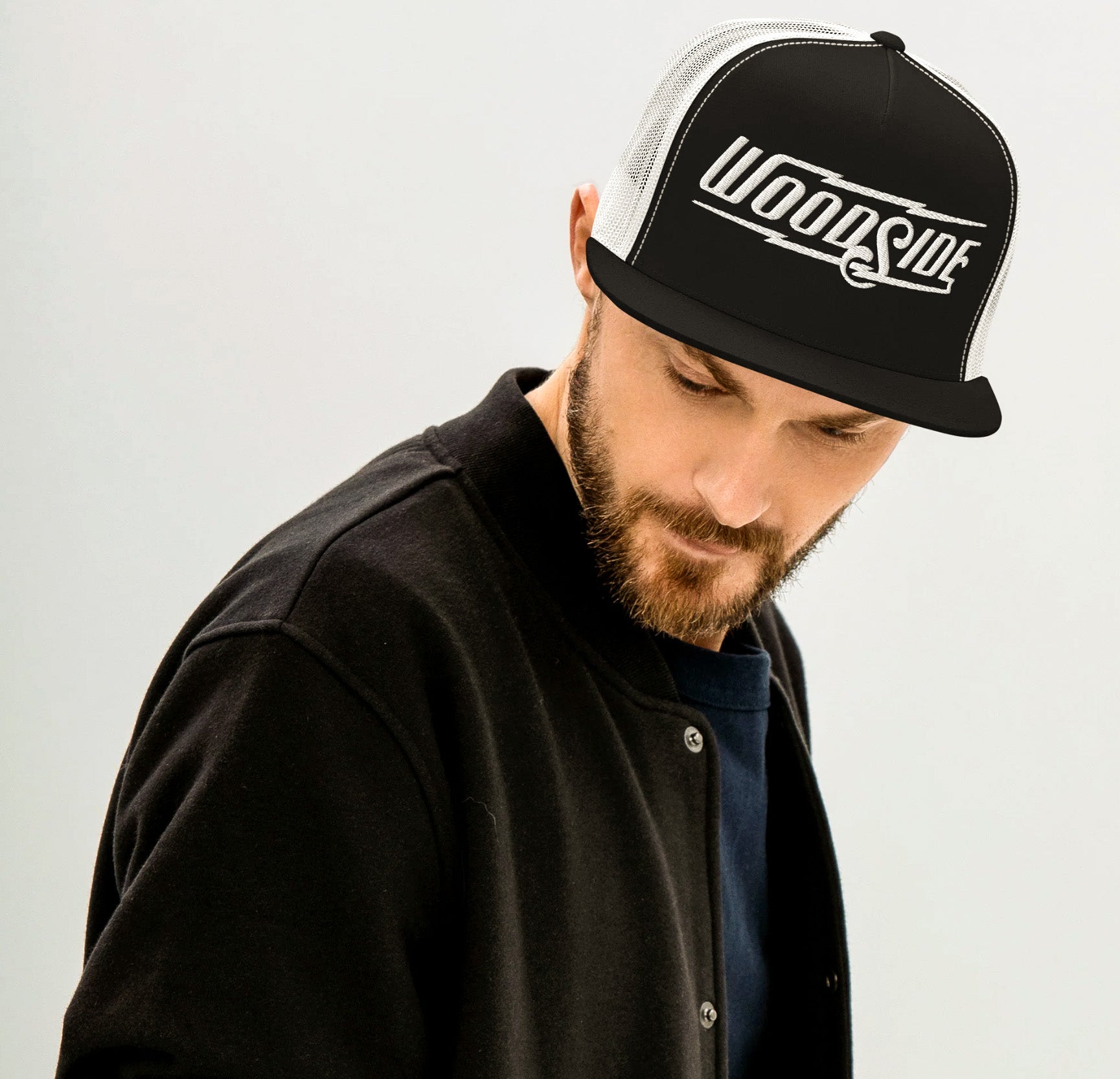 Bearded man wearing a Woodside Brand embroidered trucker hat